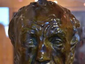 Bronze bust of Man with the Broken Nose with a wrinkled brow, deep-set eyes, and a prominent nose.