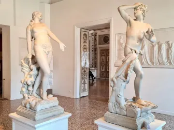 Orfeo y Eurídice marble statues displayed on pedestals in a museum gallery