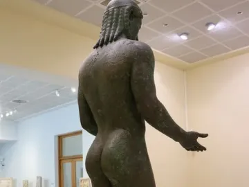 Piraeus Apollo bronze statue seen from the rear right in a museum hall