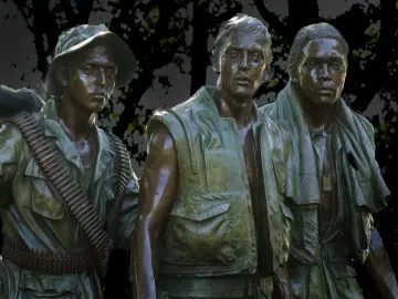 The Three Soldiers bronze sculpture showing three solemn young men in military attire.