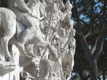 Carved white stone relief from the Antoninus Pius Column showing figures in classical dress, some on horseback and others standing with staffs.