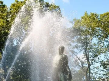 Bailey Fountain with a dark statue standing amid cascading water and mist.