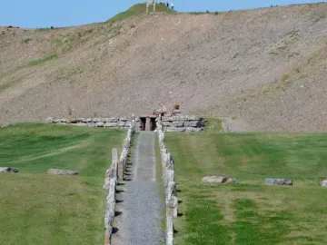 Stone rows lead along a gravel path toward the Omphalos on a hillside at Crawick Multiverse.