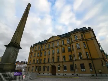 The Obelisk at Slottsbacken rises from a cobblestone plaza with people gathered around it.