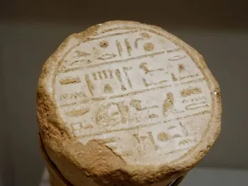 Circular end of a funerary cone with deeply incised ancient Egyptian hieroglyphs in horizontal lines.