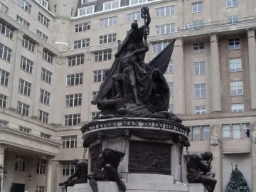 Nelson Monument with bronze figures around its stone base and a sculptural group at the top.