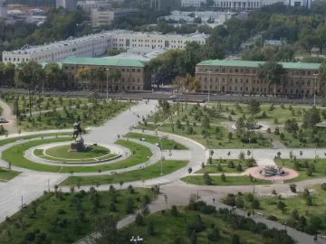 Timur equestrian statue on a pedestal in a landscaped park with lawns, trees, and paths.
