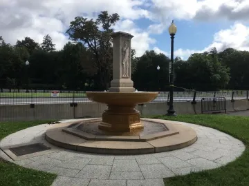 Butt-Millet Memorial Fountain with a stone figure on a central pillar and water flowing into a circular basin.