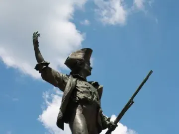 Statue of the Volunteer of 1792, a bronze soldier holding a rifle and raising one arm on a stone pedestal.