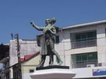 Victor Schœlcher statue showing two men on a pedestal, with one figure extending an arm toward the other.