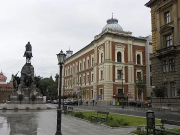 Grunwald Monument seen from the rear-left, with a bronze equestrian statue on a tiered stone plinth adorned with figures.