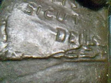 Close-up of the Monkey with a Skull sculpture showing the raised words \