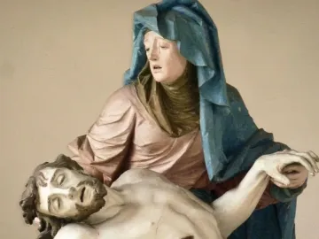 Close-up of the Nenningen Pietà showing a polychrome figure in a blue cloak supporting a lifeless bearded figure.
