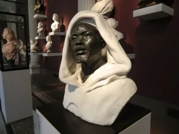 Salem, Negro of Sudan bust displayed on a pedestal in a museum hall with other portrait busts in the background.