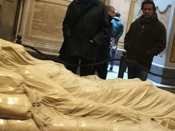 The Veiled Christ marble sculpture of a recumbent figure covered by a transparent-looking veil, with visitors in the background.