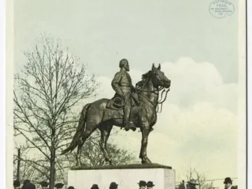 Nathan Bedford Forrest Monument shown as an equestrian statue on a stone pedestal, with a crowd gathered around it in a park.