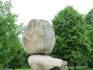 Rock on Top of Another Rock with a large boulder balanced on another stone in a park.