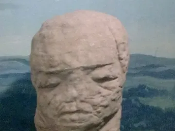 Škloŭ Idol, a weathered stone sculpture with a stylized human-like face.