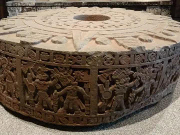 Stone of Motecuhzoma I showing a round carved monolith with concentric patterns on top and figures carved around the sides.