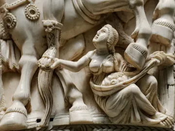 Barberini Ivory relief showing a bare-chested female figure holding up a basket beneath a horse’s legs and an armored human leg.