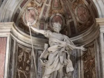 Marble statue of St. Longinus holding a spear in a decorated niche at St. Peter\'s Basilica.