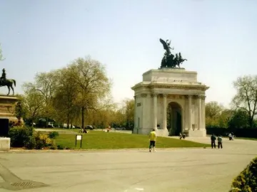 The Duke of Wellington statue on horseback atop a stone pedestal, with Wellington Arch and a winged sculpture in the background.