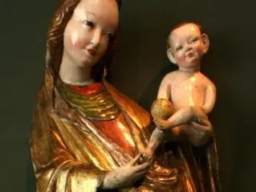 Madonna of Krużlowa holding the Christ Child, shown in flowing gold and red robes.