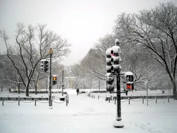 Dupont Circle Fountain in a snow-covered plaza with bare trees and traffic lights nearby