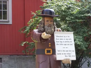 Rosenbom, a life-size wooden figure of a bearded man in historical clothing, holding out one hand and a scroll.