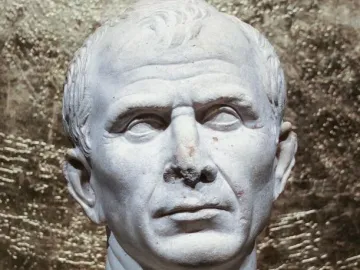 Weathered white marble bust of an older man with short wavy hair and a serious expression.