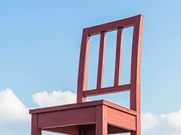 Broken Chair sculpture with a shattered leg towering over people in Geneva.