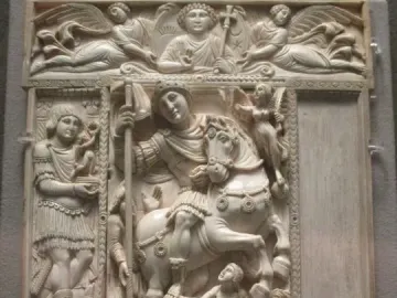 Barberini Ivory panel with a central relief of a mounted warrior holding a staff, surrounded by smaller carved figures and celestial scenes.