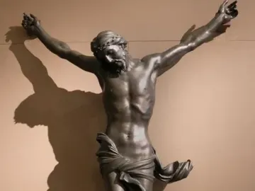 Bernini\'s Corpus, a dark bronze crucified Christ with outstretched arms, bowed head, and crown of thorns.