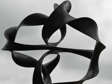 Continuum sculpture with twisting black metal ribbons on a tall pedestal against an overcast sky.