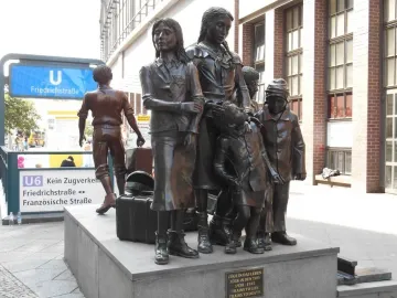 Trains to Life – Trains to Death monument showing several bronze children on a stone base with a plaque.