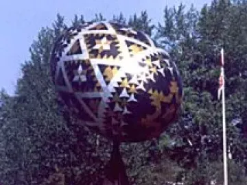 Vegreville Pysanka sculpture with geometric silver, gold, and dark patterns on a pedestal.