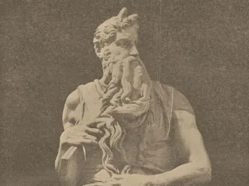 Seated statue of Moses with a long curly beard, horns, and tablets under his arm.