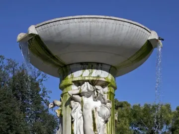 Dupont Circle Fountain with cascading water, classical figures carved on the central shaft, and green-stained marble.
