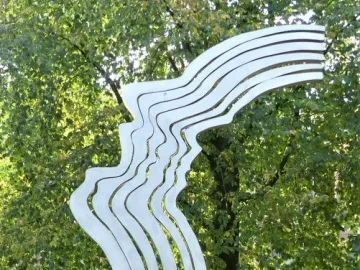De Schreeuw sculpture with six wavy steel strips forming a face in a park