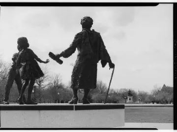 Rear view of the Mary McLeod Bethune Memorial bronze statue with the Emancipation Statue and Capitol dome in the background.