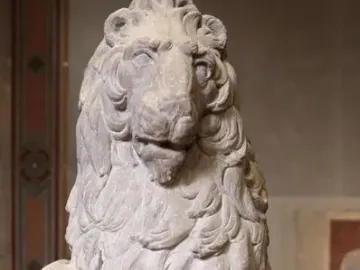 Marzocco stone lion with its paw resting on a shield bearing a fleur-de-lis.