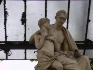 Monument to Nicola Demidoff showing a seated older figure holding a standing child beneath a glass and metal roof.