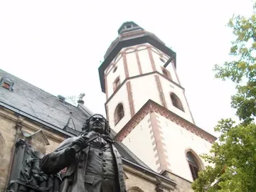 New Bach Monument statue in front of St. Thomas Church with the church tower behind it
