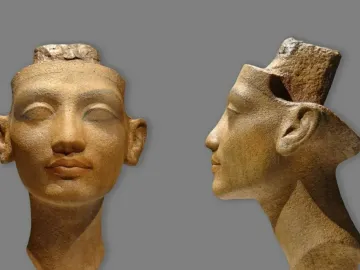 Unfinished Head of Nefertiti shown from the front and in profile, with delicate carved features and a rough, incomplete top.