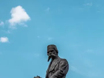 Vuk Karadžić Monument showing a bronze seated figure holding an open book on a stone pedestal.