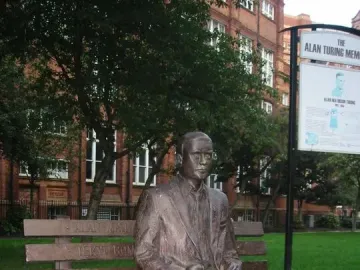 Alan Turing Memorial bronze statue seated on a park bench holding an apple.