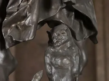 Close-up of the Gloria Victis bronze sculpture showing an owl perched on a leafy branch beneath draped forms.