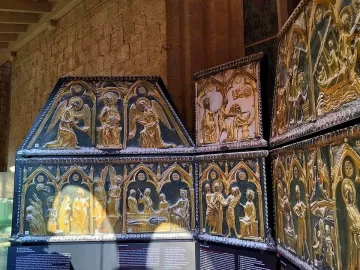 Sant Cugat Casket with ornate gilded panels showing embossed figures and architectural scenes.