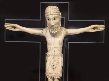 Carrizo Christ carved ivory figure with outstretched arms on a dark cross-shaped background