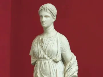 Artemis Diadoumena marble statue with braided hair and draped garments, missing the lower arms.
